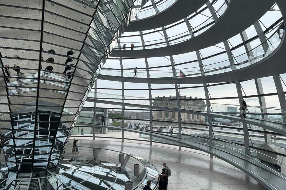 德国国会大厦圆顶是一个玻璃圆顶，建在柏林重建的德国国会大厦顶部。它由建筑师诺曼·福斯特设计，旨在象征德国的统一。圆顶中央的镜面锥体将阳光引入建筑物，以便游客可以看到房间的工作情况。